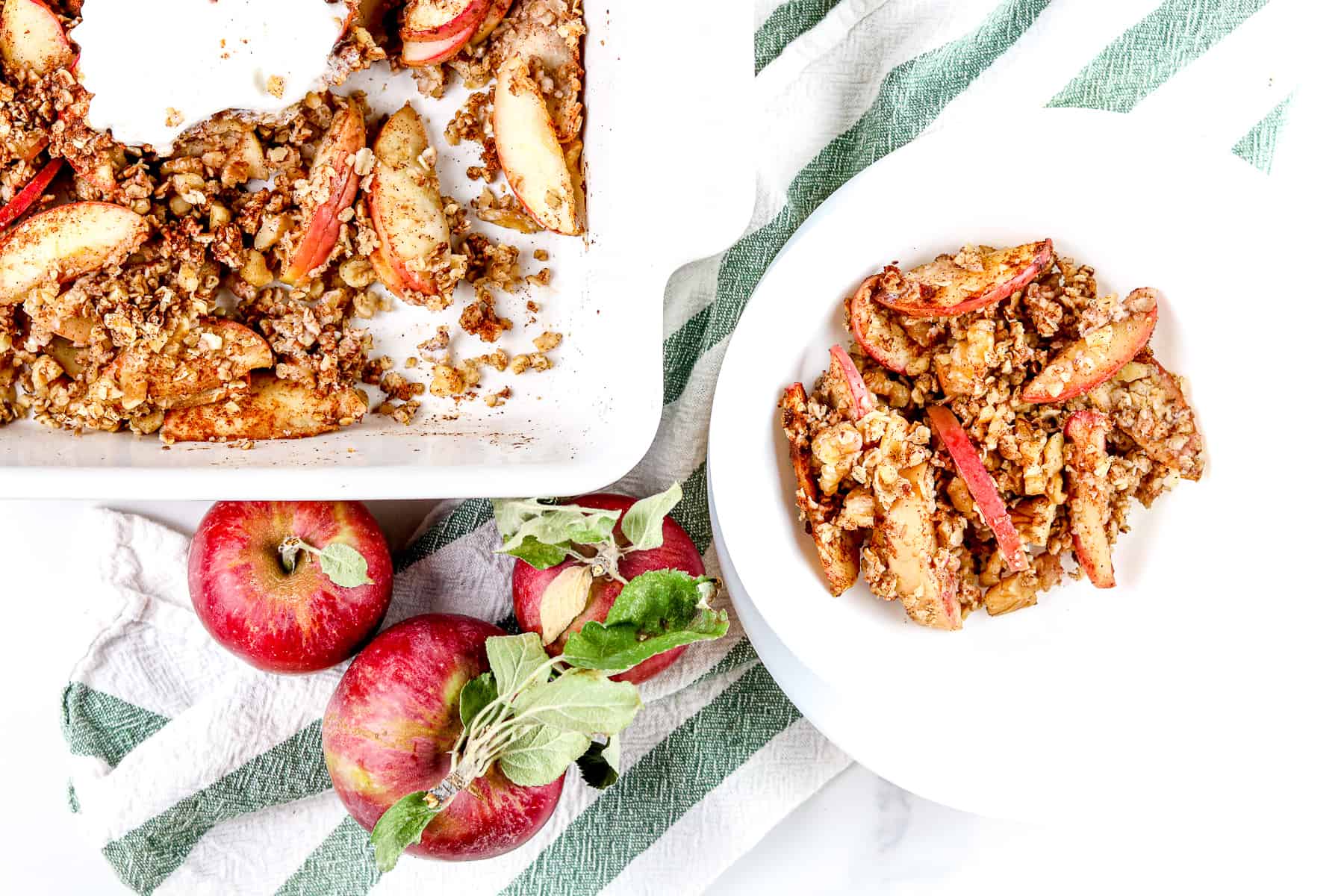 Image of plated apple crisp in a bowl with larger dish next to it. 