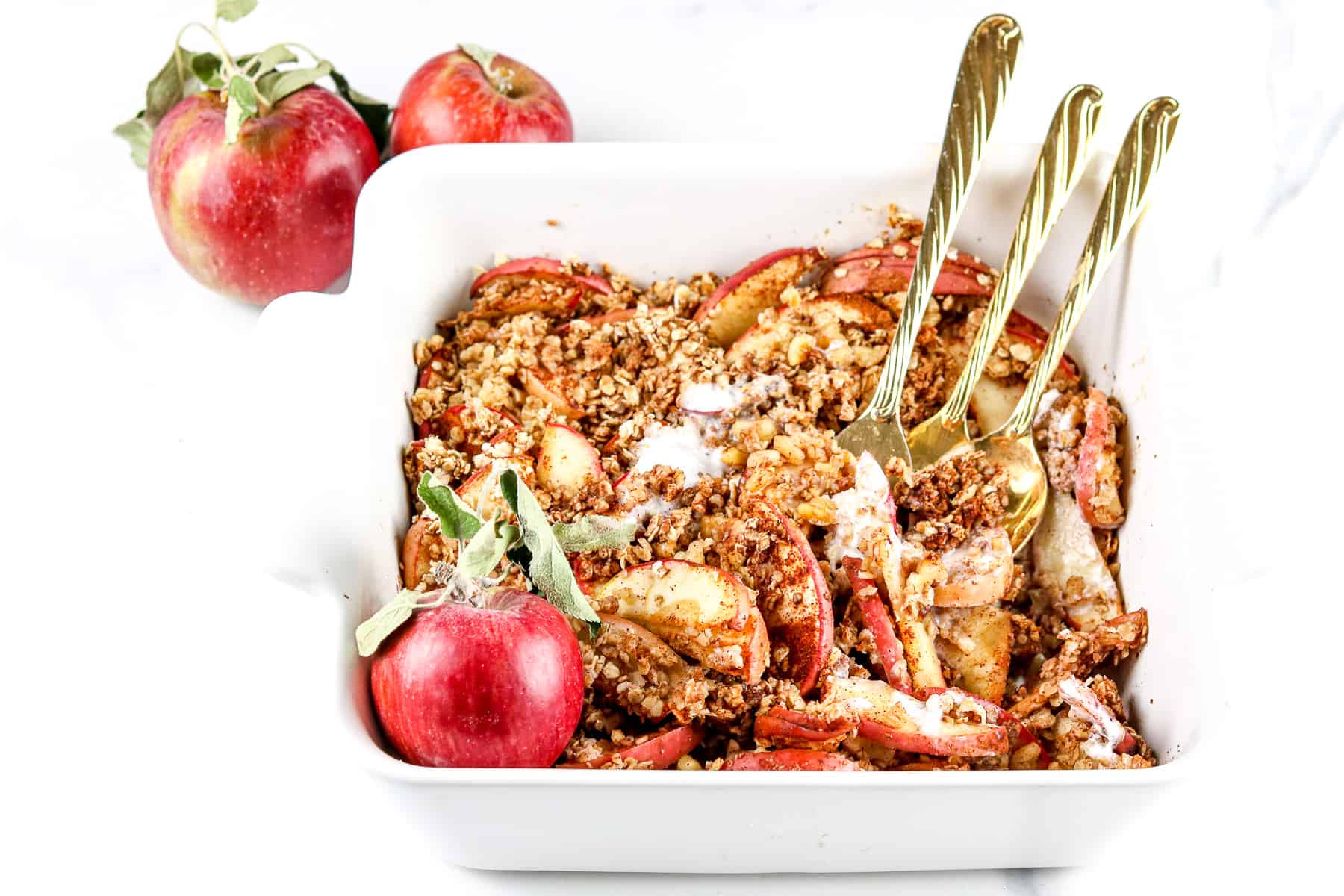 Image of apple crisp in a baking dish with forks.