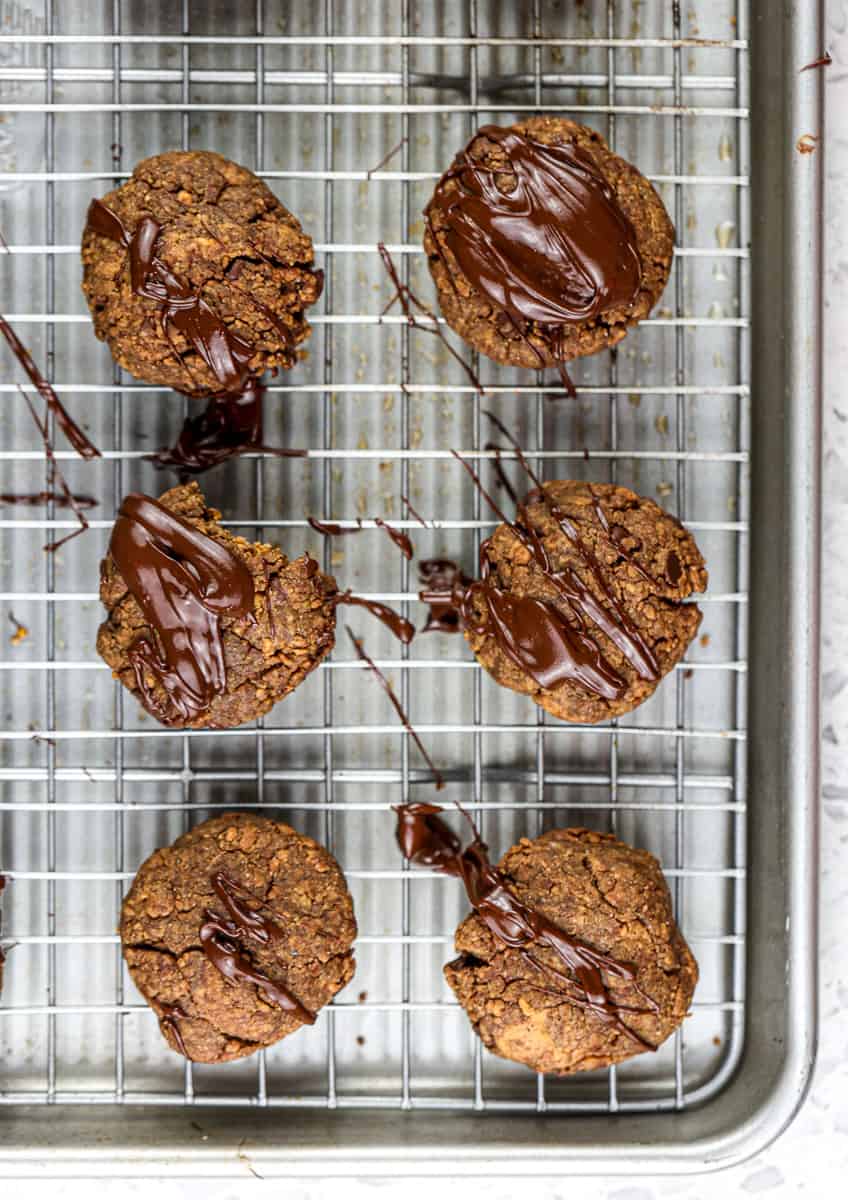 Image of 6 chocolate cookies on a baking sheet with chocolate glaze.