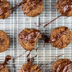 Baked cookies on silver baking sheet with chocolate glaze over the top.