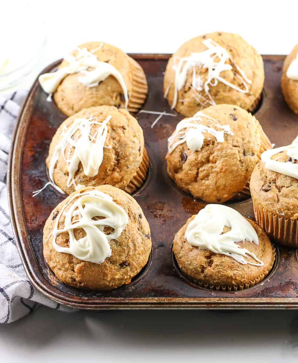 Sweet potato chia chocolate breakfast cupcakes in a muffin tin with yogurt glaze drizzled on top.