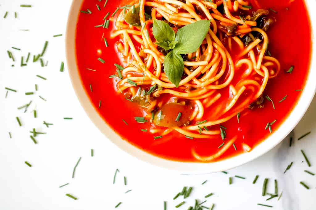 Tomato Soup Pasta with Kale is a simple, vegan dish that the entire family can enjoy. Make It from scratch or simple swap some time with using a canned soup. Either way, the end product is delicious! You'll also find suggestions to modify for a gluten-free diet and high protein soup.  #tomatosoup #healthytomatosoup #vegansouprecipes