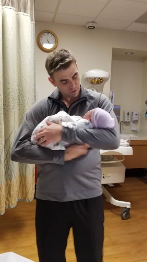 Dad holding daughter for the first time.