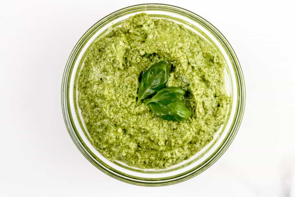 Image of walnut pesto sauce with basil on top.