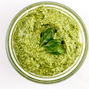 Image of walnut pesto sauce with basil on top.