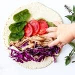Baby Hand reaching to grab the walnut pesto wrap.
