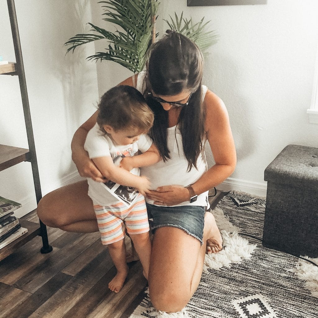 Image of toddler and mom holding ultrasound photo.