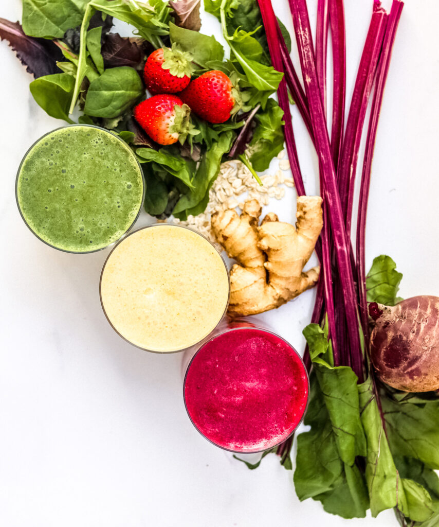 White backdrop with three smoothies and beet greens.