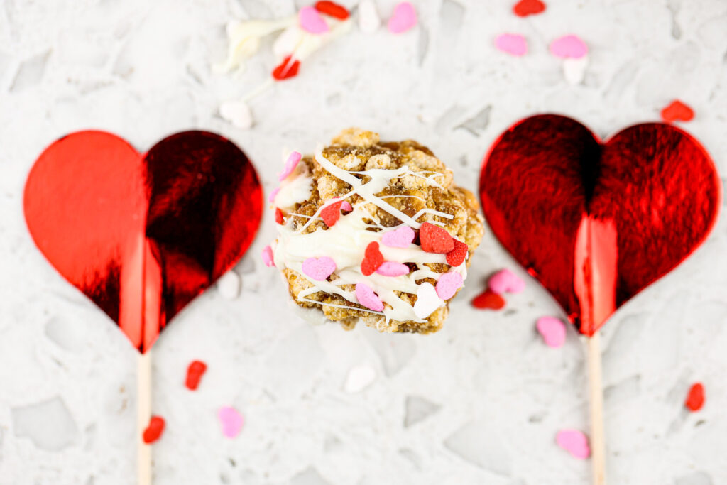 White marble backdrop with cereal cake pop and two hearts on the side.