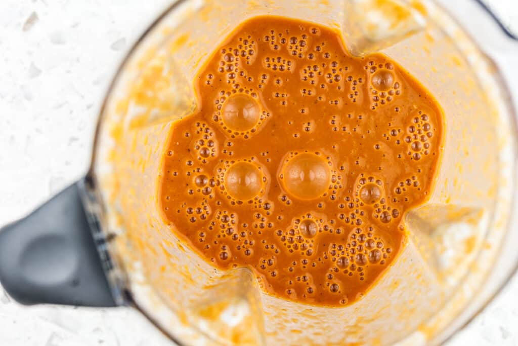 Picture of red sauce with bubbles in blender.