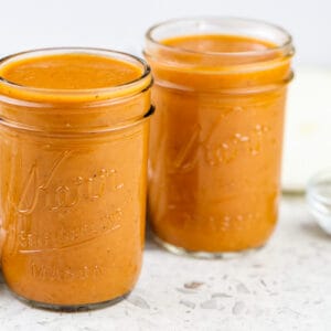 White marble backdrop with two mason jars of habanero bbq sauce.