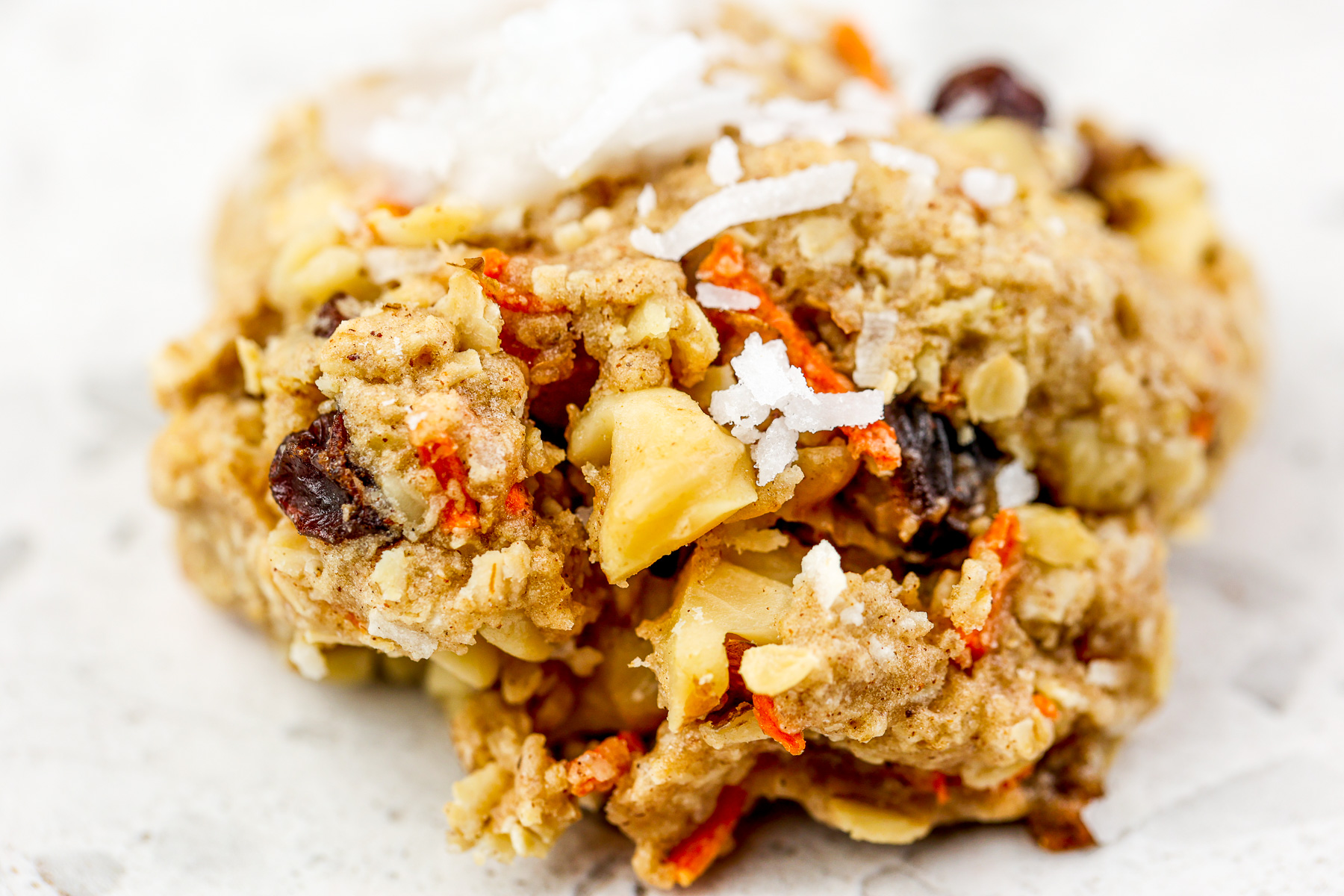 White marble backdrop with single cookie on top with one bite out of it.