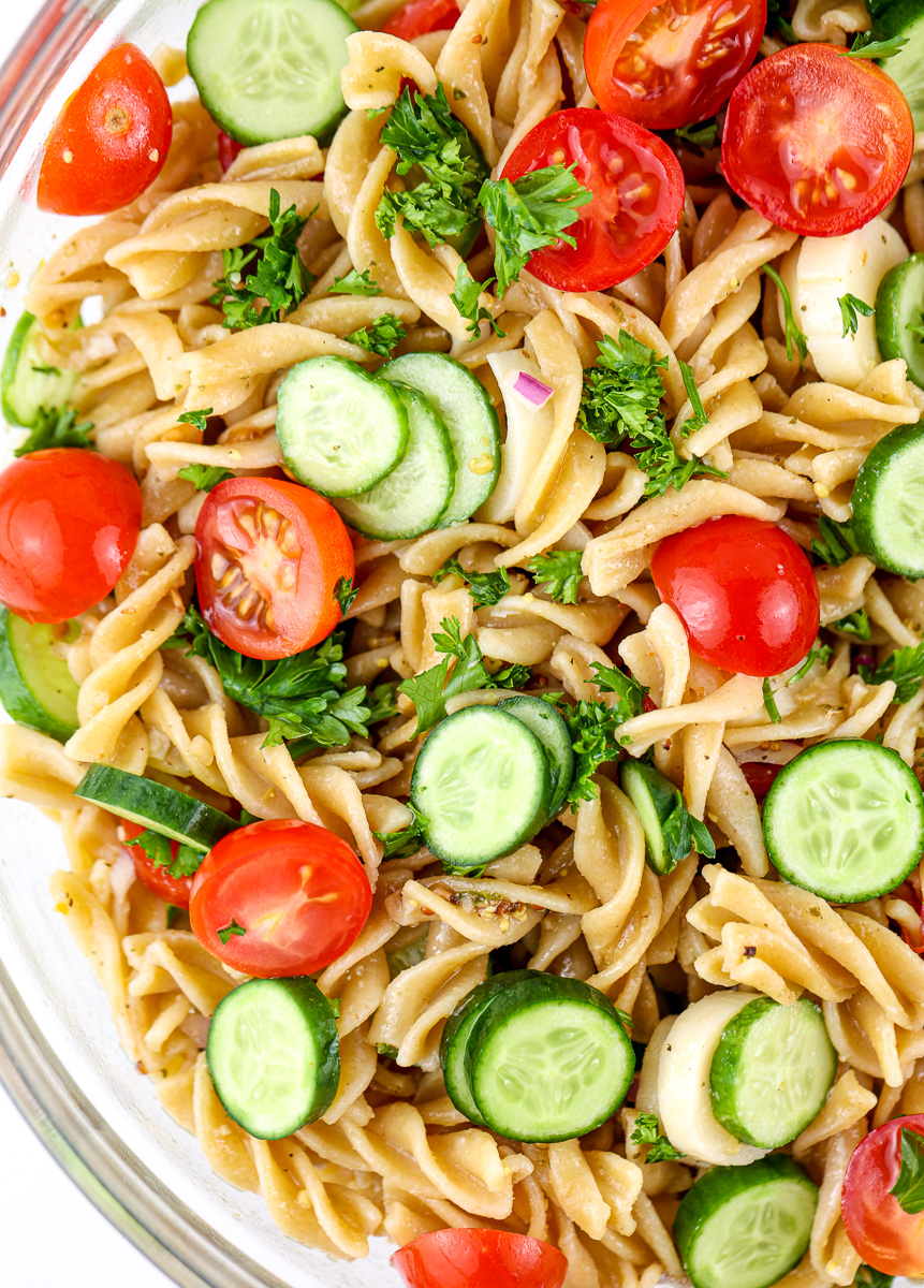 Close up shot of whole grain pasta tossed with veggies for Mediterranean Pasta Salad.