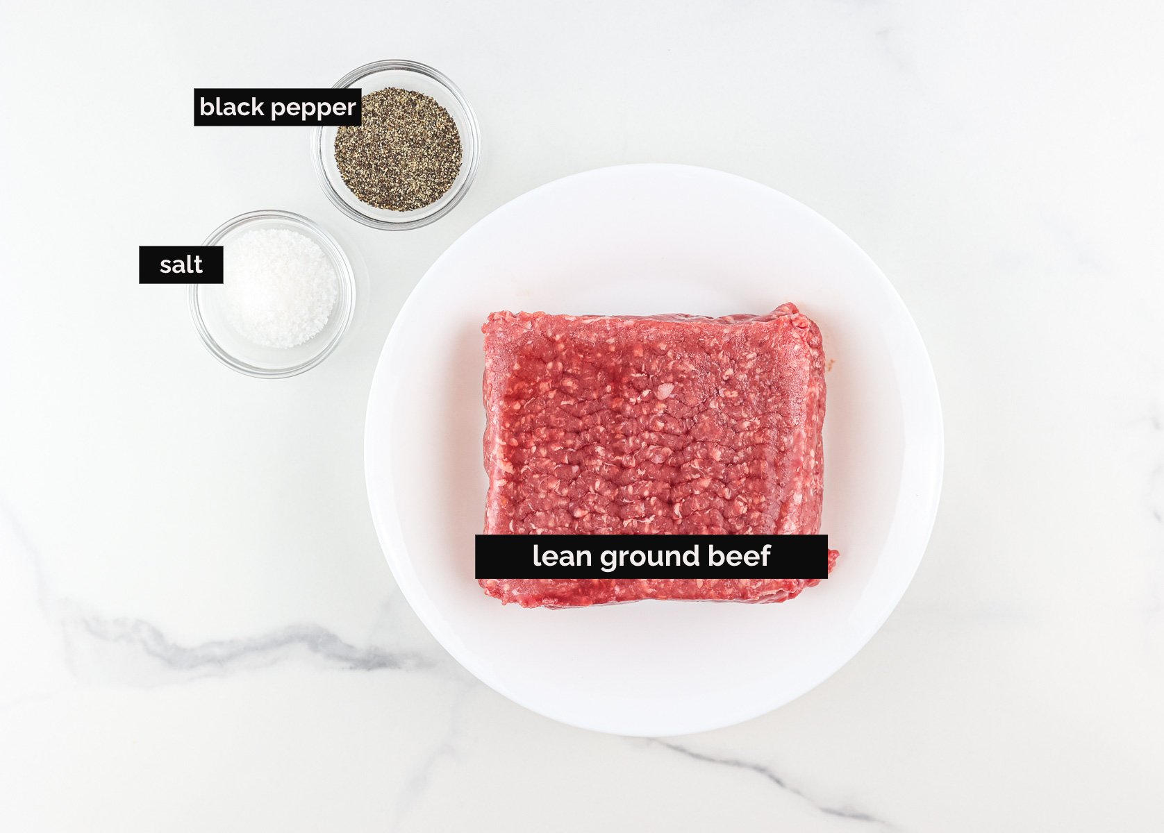 White background with ingredients to make beef burgers,