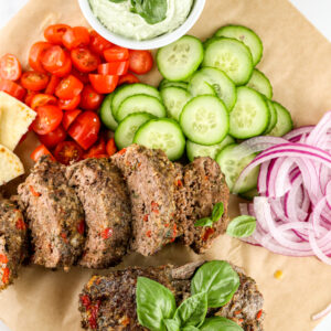Air fryer meatloaf on brown parchment paper with veggies.