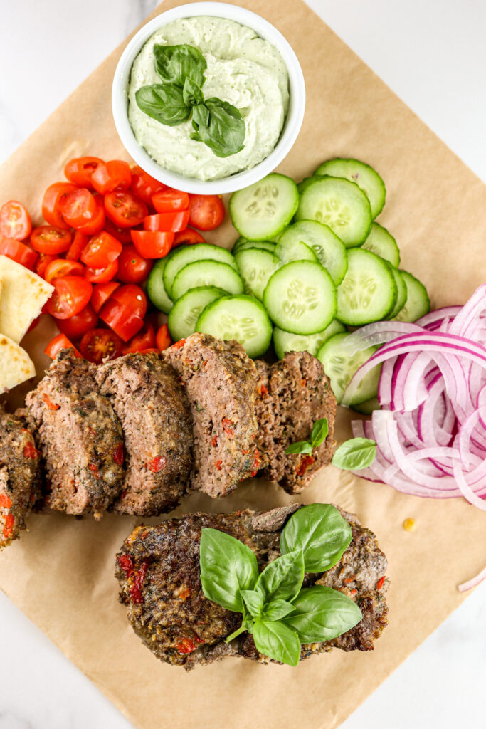 Air fryer meatloaf on brown parchment paper with veggies.