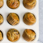 Muffins in muffin tin with grey background for food photography styling.